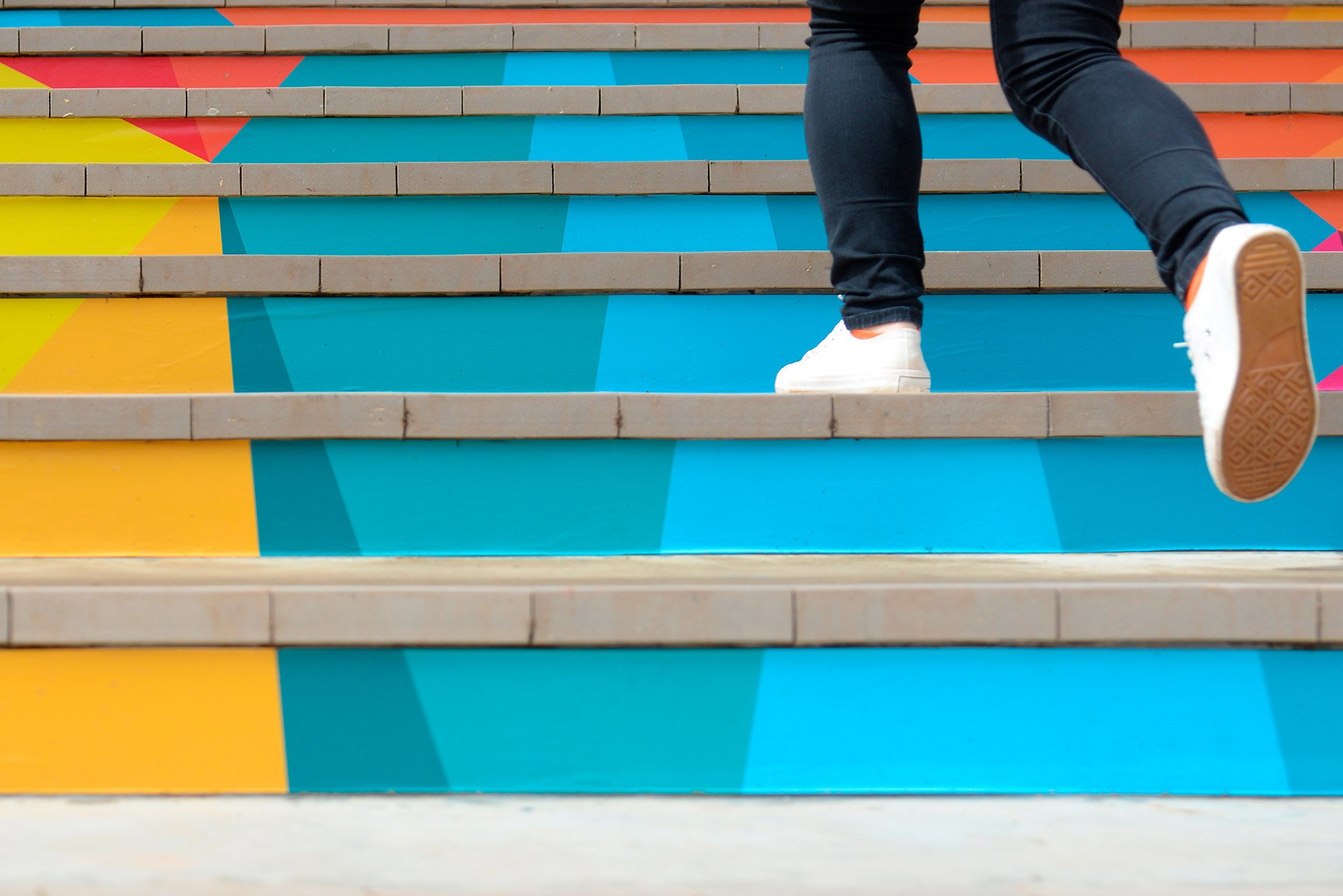 Mujer subiendo escalas de colores